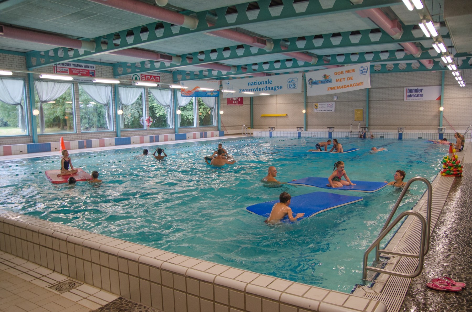 Bezoekers zwemmen en spelen in het wedstrijdbad van De Meerval